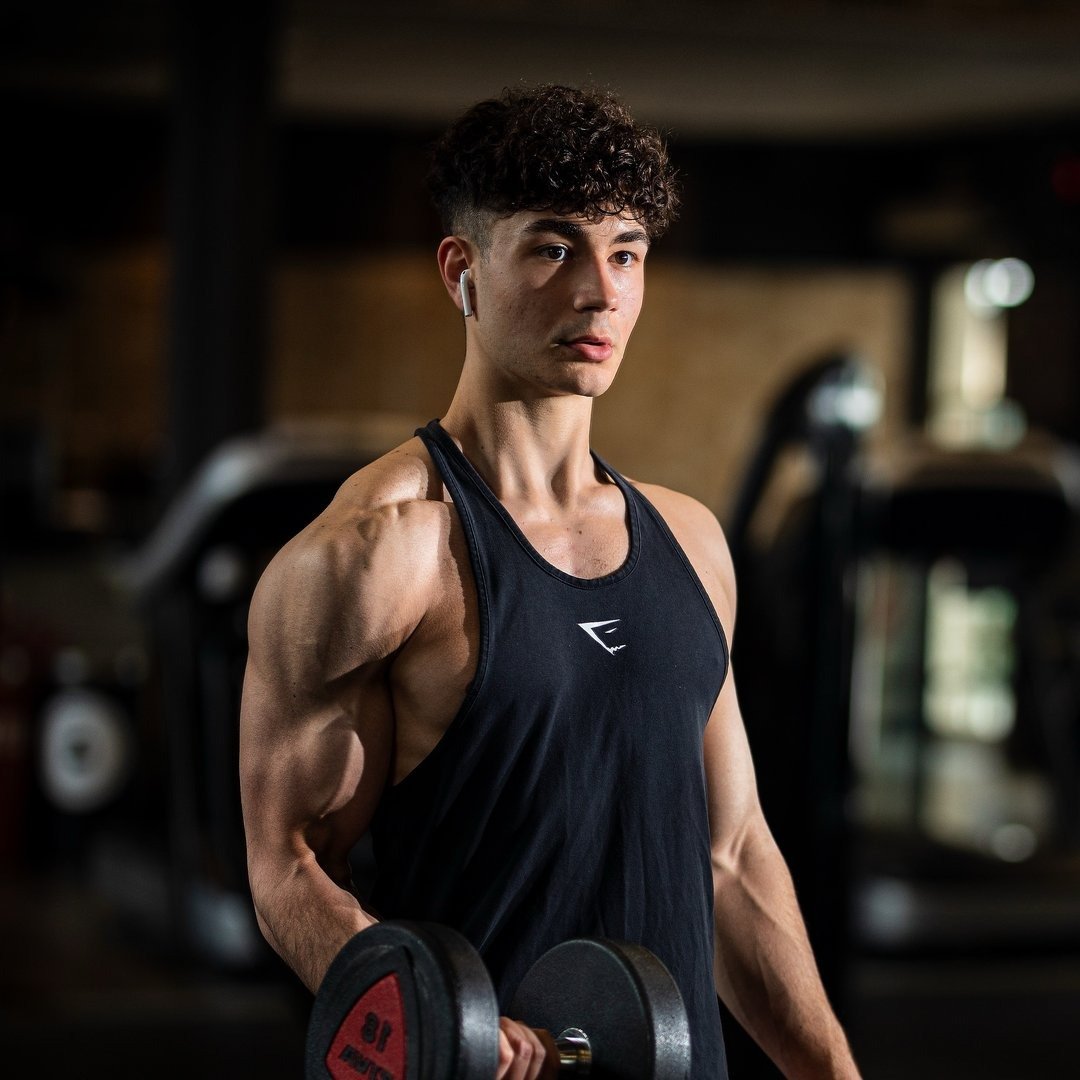 Pietro Mercolini in palestra che alza un peso da 12kg